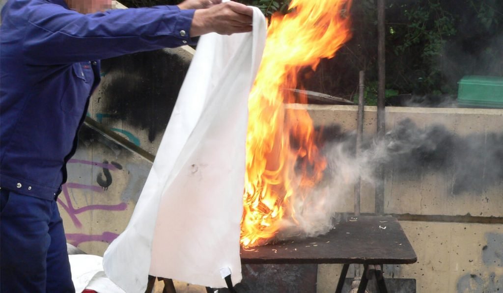 putting out fire with fire blanket